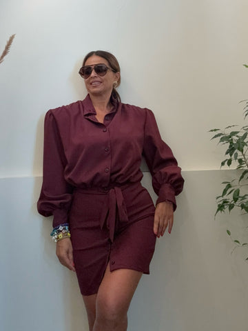 Modella indossa un abito chemisier bordeaux Amuleto® Fashion Store con maniche a palloncino e cintura in vita